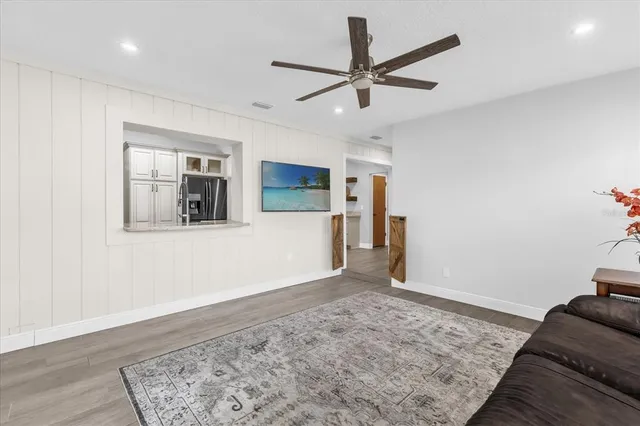 a view of a livingroom with wooden floor and a ceiling fan