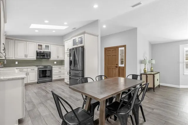 a open kitchen with kitchen island a dining table and chairs
