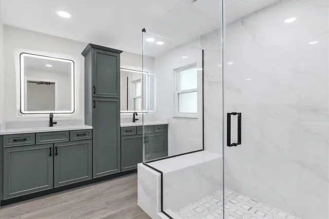 a bathroom with a double vanity sink mirror and shower