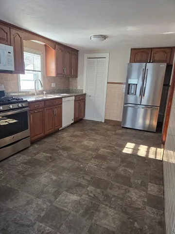 a kitchen with stainless steel appliances granite countertop a stove a sink and a refrigerator