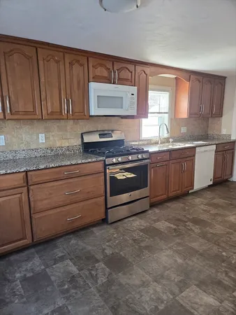 a kitchen with stainless steel appliances granite countertop a stove a sink dishwasher and cabinets
