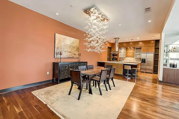 a dining room with furniture a chandelier and wooden floor