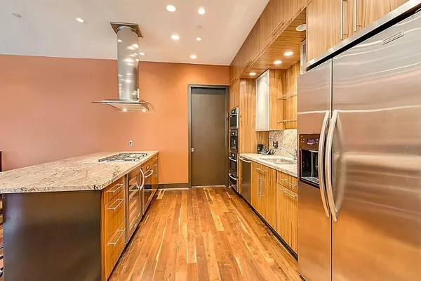 a kitchen with stainless steel appliances granite countertop a refrigerator a sink and a stove