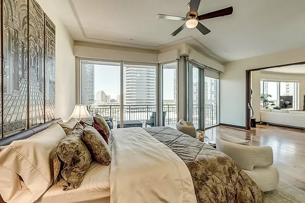 a bedroom with a bed couch and large window