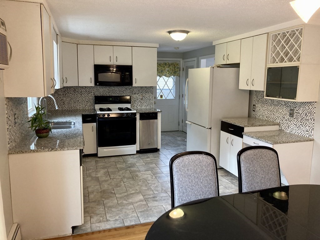 119 Westmoor Road Boston, MA 02132 - Photo 13 of 22 a kitchen with stainless steel appliances granite countertop a stove top oven a sink a refrigerator and a microwave