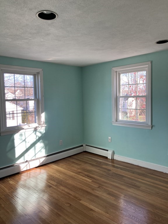 119 Westmoor Road Boston, MA 02132 - Photo 5 of 22 an empty room with wooden floor and windows