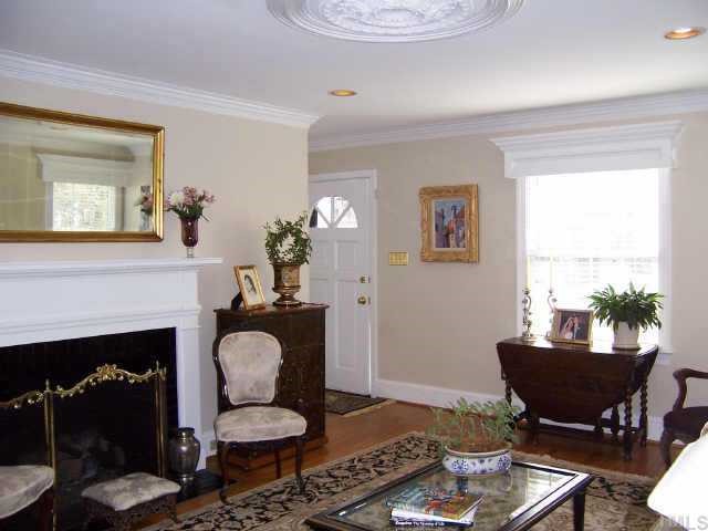 3122 Georgian Terrace Raleigh, NC 27607 - Photo 3 of 12 a living room with furniture a fireplace and a potted plant