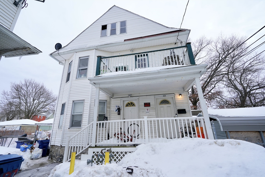 183 Farnham Street Lawrence, MA 01843 - Photo 1 of 38 a view of a white house with large windows and a small yard