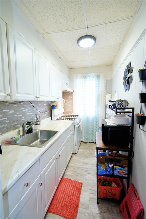183 Farnham Street Lawrence, MA 01843 - Photo 5 of 38 a kitchen with stainless steel appliances a stove a sink and a microwave
