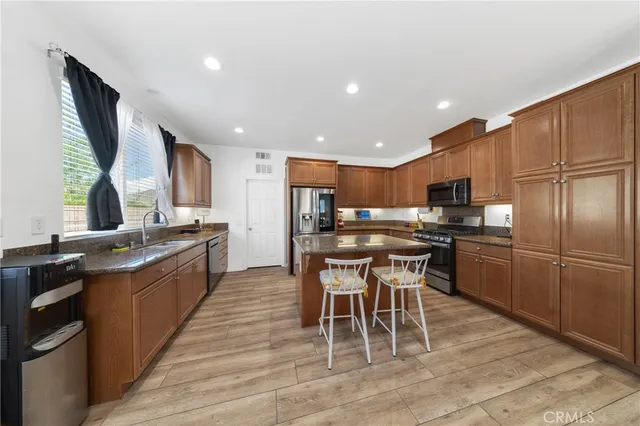 a kitchen with stainless steel appliances kitchen island granite countertop a sink and cabinets