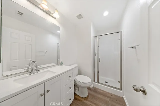 a bathroom with a double vanity sink toilet mirror and shower