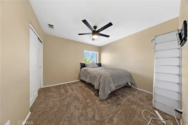 a bedroom with a bed and a ceiling fan