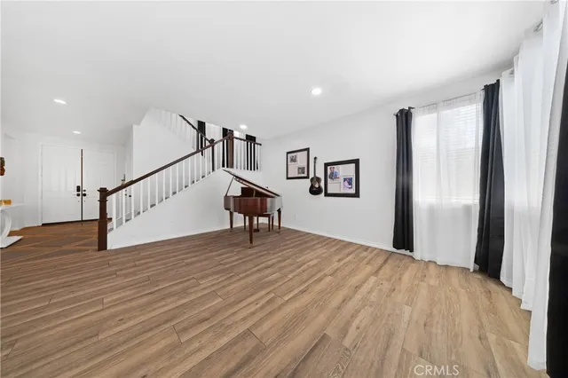 a view of a livingroom with wooden floor and staircase