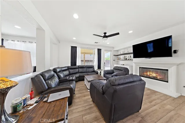 a living room with furniture a fireplace and a flat screen tv