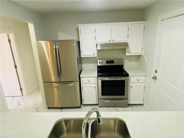 a kitchen with a refrigerator and a stove