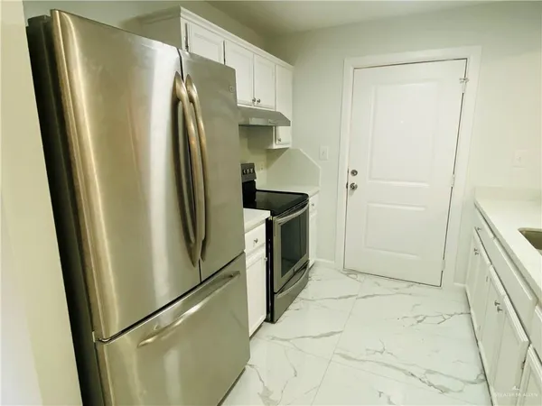 a metallic refrigerator freezer sitting in a kitchen