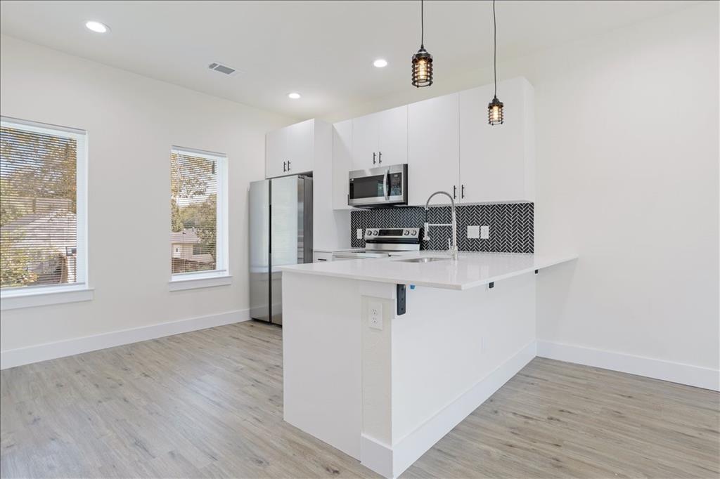 515 South 1st Street, Unit 8 Sherman, TX 75090 - Photo 5 of 7 a view of kitchen with stainless steel appliances granite countertop a stove top oven a refrigerator a sink and dishwasher with wooden floor