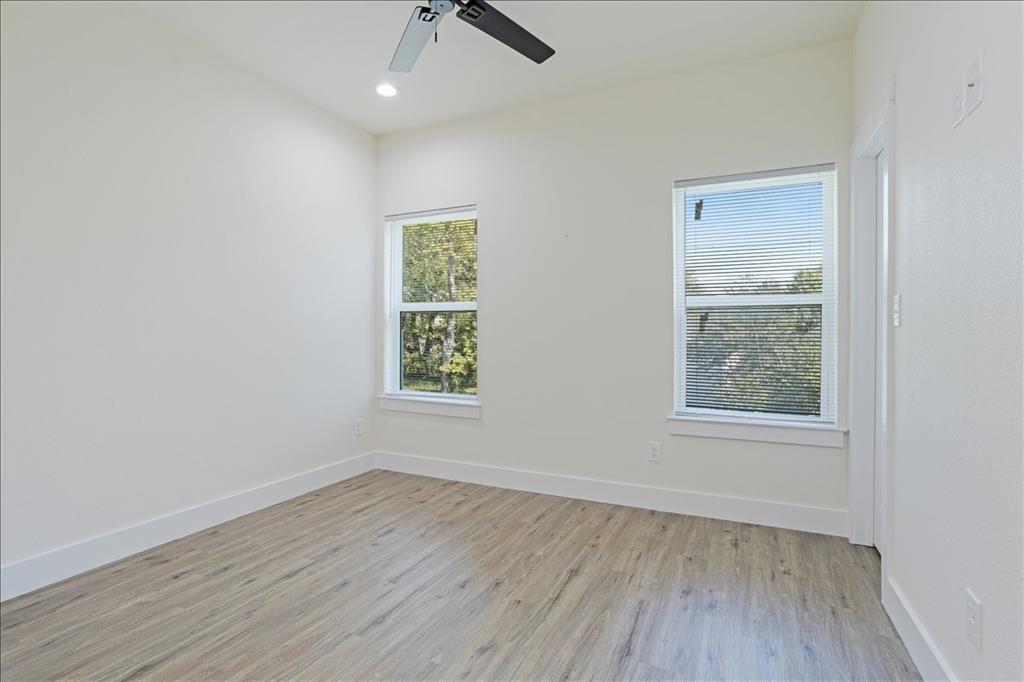 515 South 1st Street, Unit 8 Sherman, TX 75090 - Photo 7 of 7 an empty room with wooden floor and windows