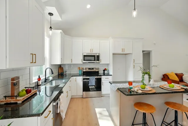 a kitchen with a sink stove top oven and microwave