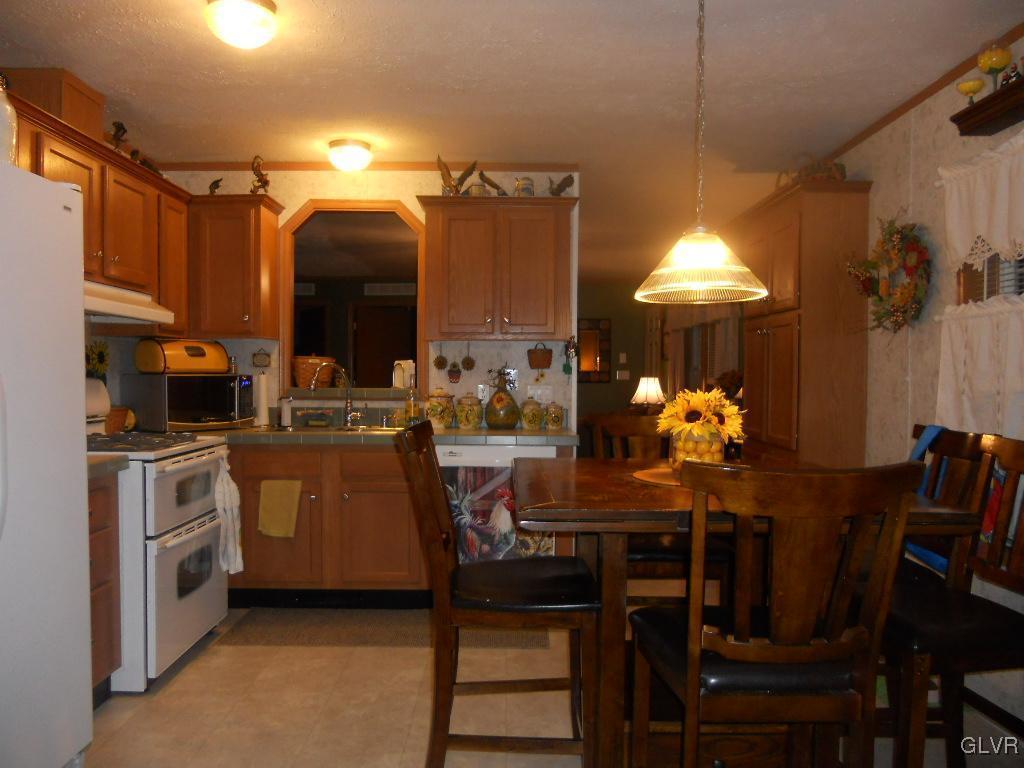 8733 Turkey Ridge Road Breinigsville, PA 18031 - Photo 3 of 19 a kitchen with stainless steel appliances kitchen island granite countertop a table and chairs in it