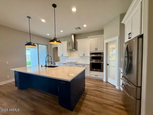 a kitchen with kitchen island a counter top a stove a refrigerator and a sink
