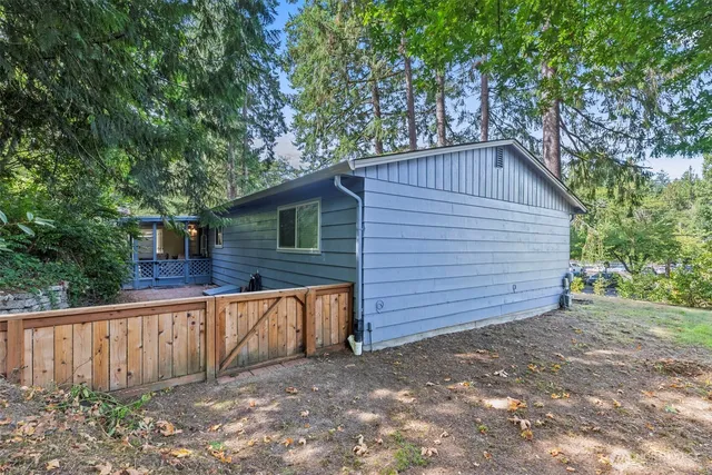a view of a small house with wooden fence