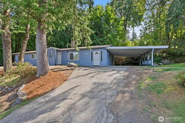 a view of a house with backyard and trees