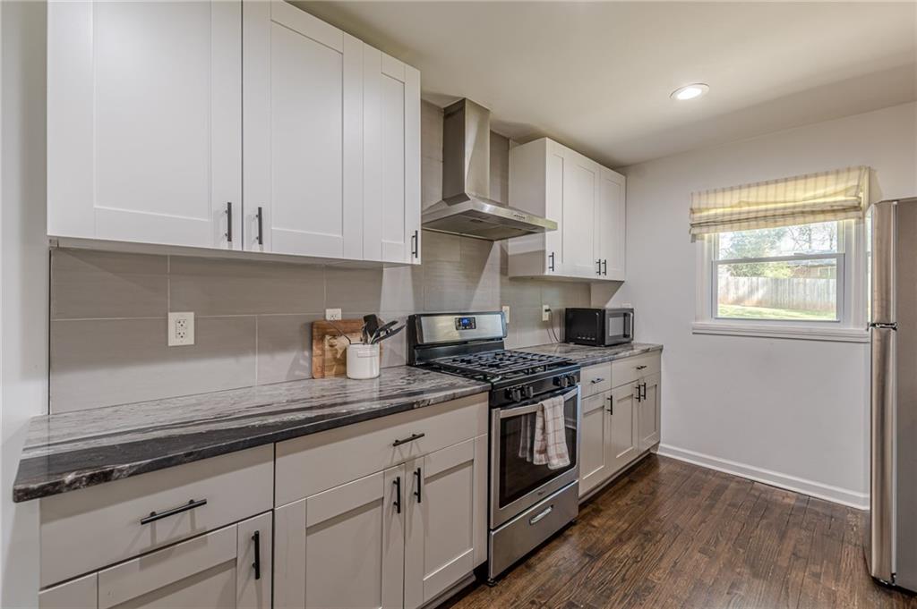 1692 Derrill Drive Decatur, GA 30032 - Photo 6 of 29 a kitchen with stainless steel appliances granite countertop a stove a sink and white cabinets