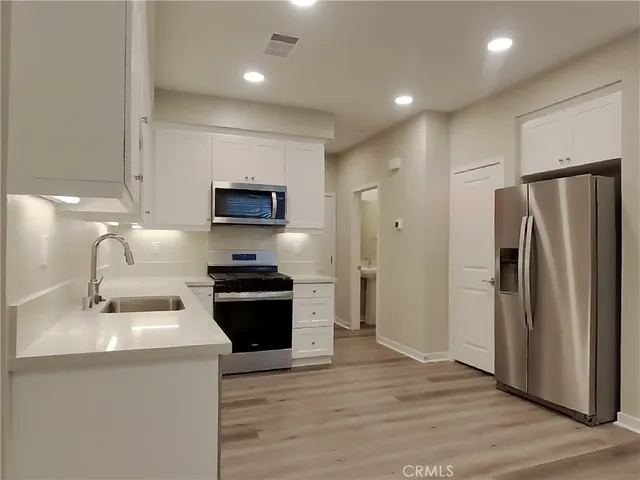 a kitchen with stainless steel appliances granite countertop a refrigerator stove and sink