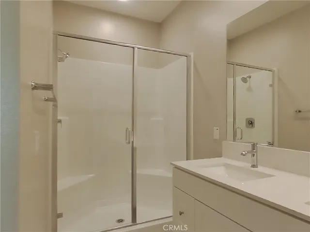 a bathroom with a shower sink vanity granite and shower