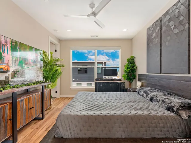 a bedroom with a bed television and a large window