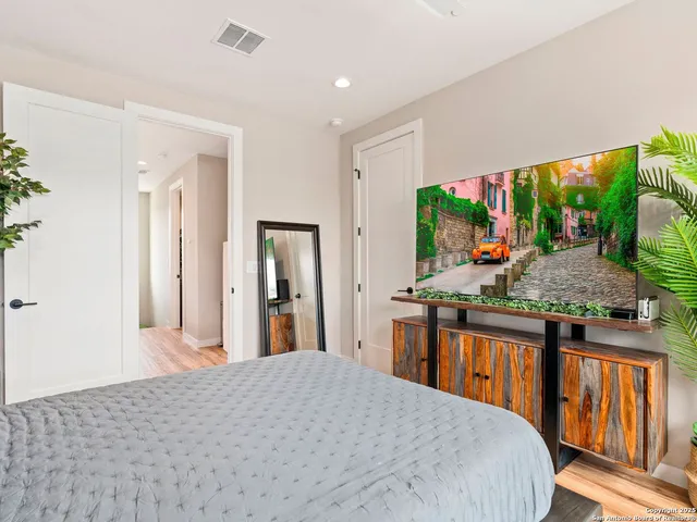a bedroom with large window and flat screen tv
