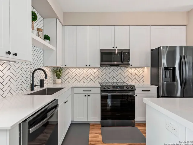 a kitchen with granite countertop a stove sink and refrigerator