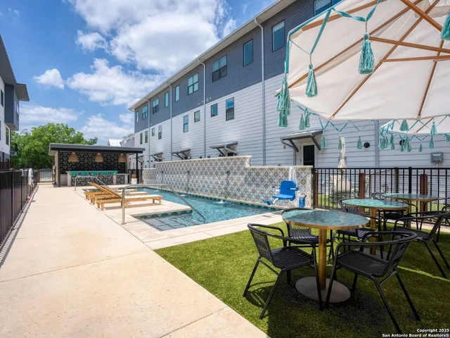 a view of backyard with swimming pool and furniture