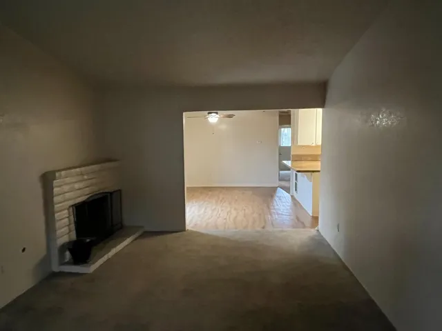 a view of empty room with wooden floor and fireplace