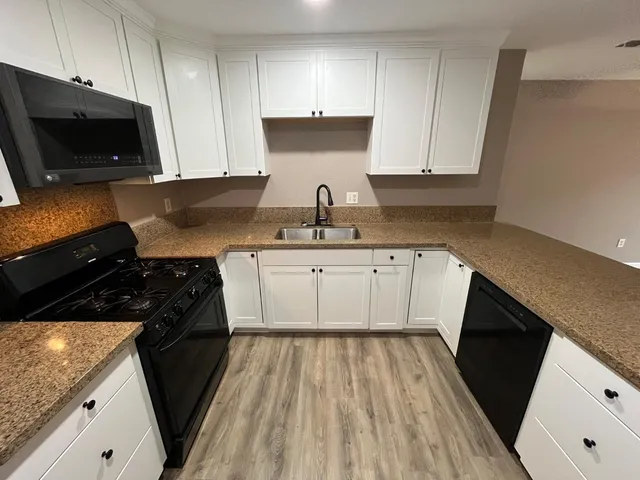 a kitchen with a sink stove and cabinets