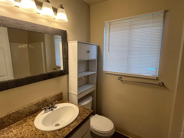 a bathroom with a toilet a sink and mirror