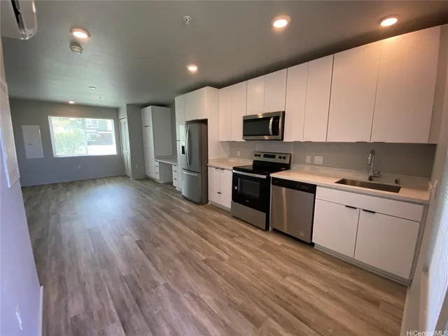 a kitchen with granite countertop a sink cabinets and stainless steel appliances