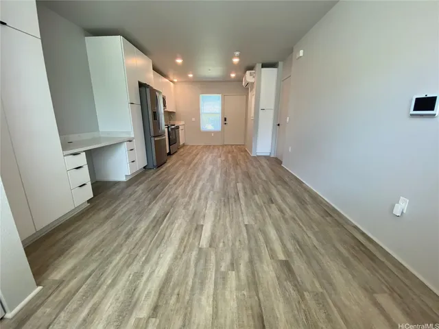 a view of empty room with wooden floor