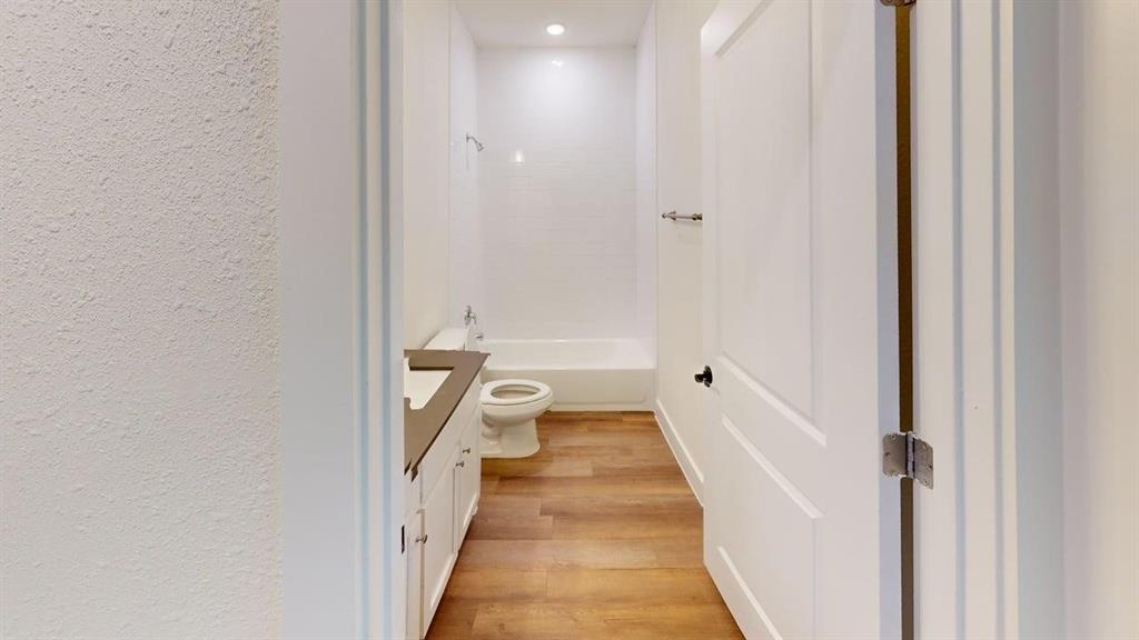 353 Buck Ridge Drive Little Elm, TX 75068 - Photo 17 of 23 Bathroom featuring vanity, light wood-style flooring, tub / shower combination, a textured wall, and recessed lighting