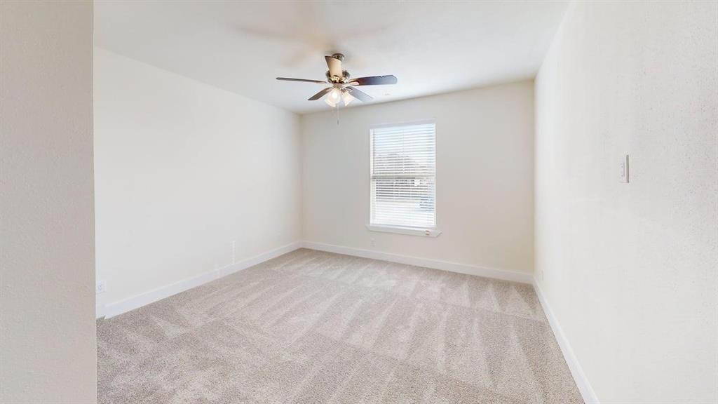 353 Buck Ridge Drive Little Elm, TX 75068 - Photo 9 of 23 Unfurnished room with light colored carpet and a ceiling fan