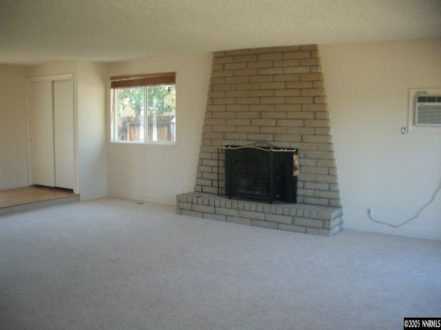 13905 Chamy Drive Reno, NV 89521 - Photo 5 of 9 an empty room with a fireplace