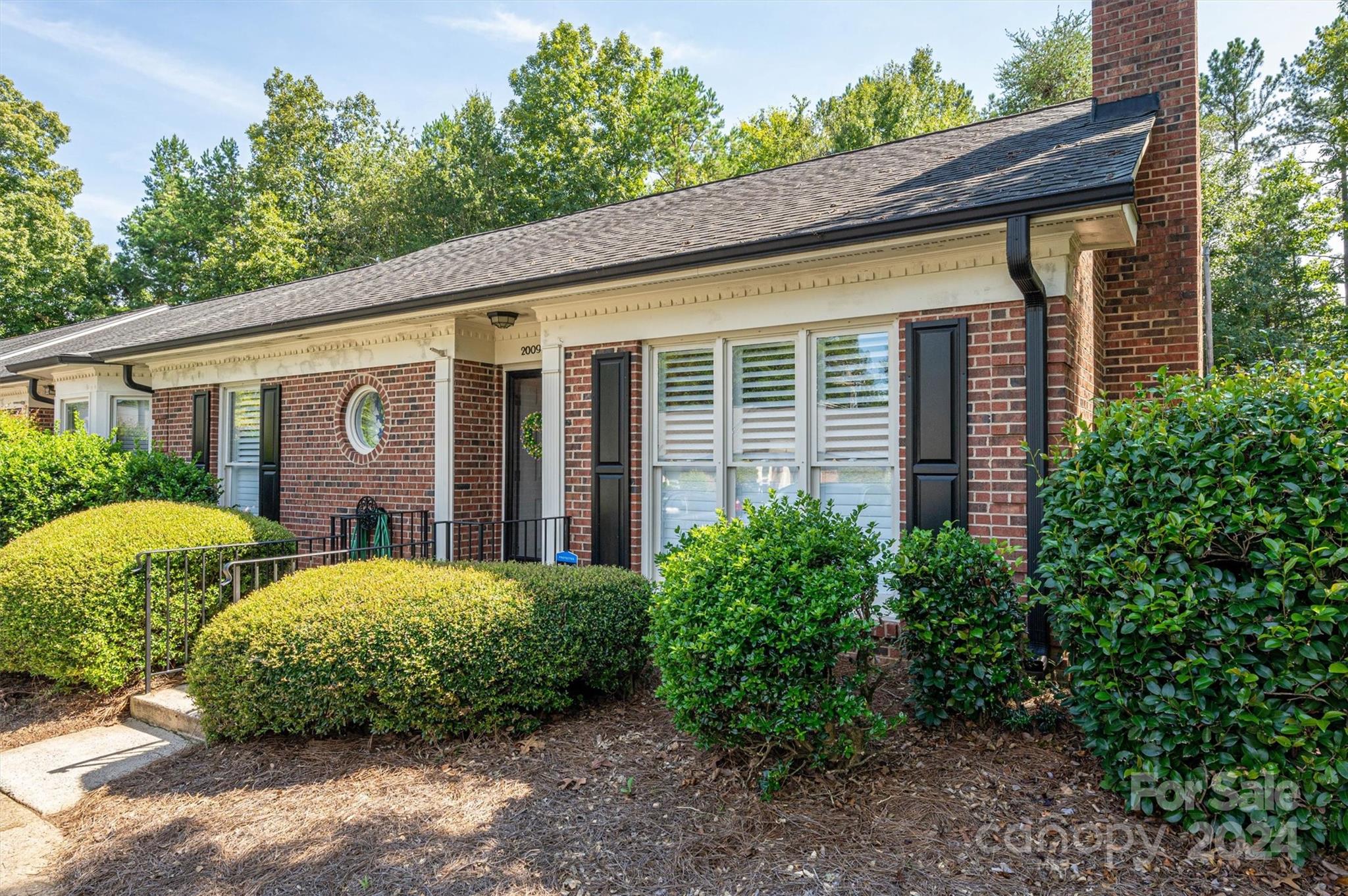 2009 Union Road, Unit E Gastonia, NC 28054 - Photo 1 of 17 a view of a house with brick walls plants and large tree