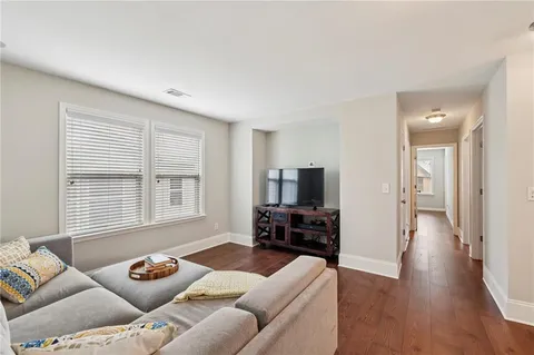a living room with furniture and a flat screen tv with wooden floor