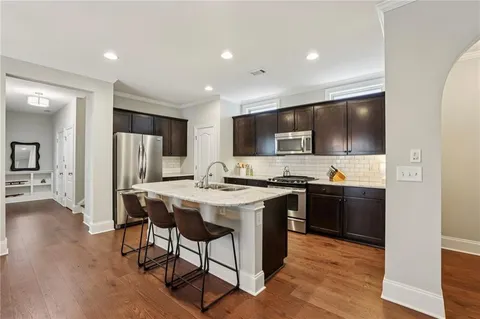 a kitchen with stainless steel appliances kitchen island granite countertop a stove refrigerator and microwave