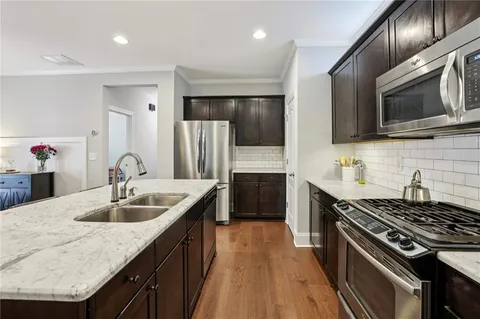 a kitchen with stainless steel appliances granite countertop a sink stove and refrigerator