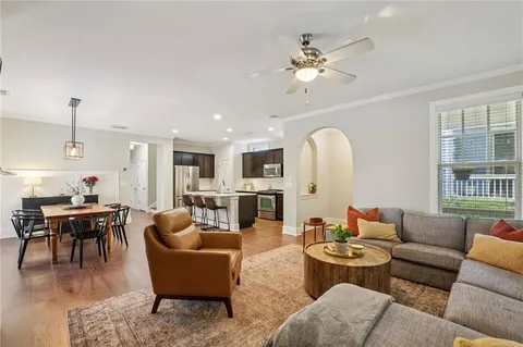 a living room with furniture kitchen view and a chandelier