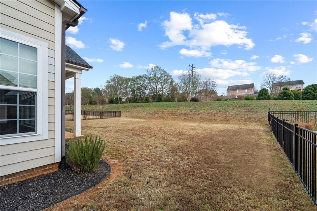 102 Ripplestone Way Anderson, SC 29621 - Photo 34 of 39 A spacious backyard with secure fencing, offering privacy and a wide-open vista under an expansive sky.