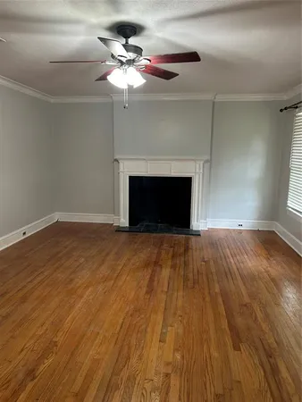 a view of empty room with wooden floor and fireplace