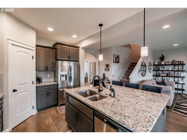 a view of a dining room and livingroom with furniture wooden floor a chandelier
